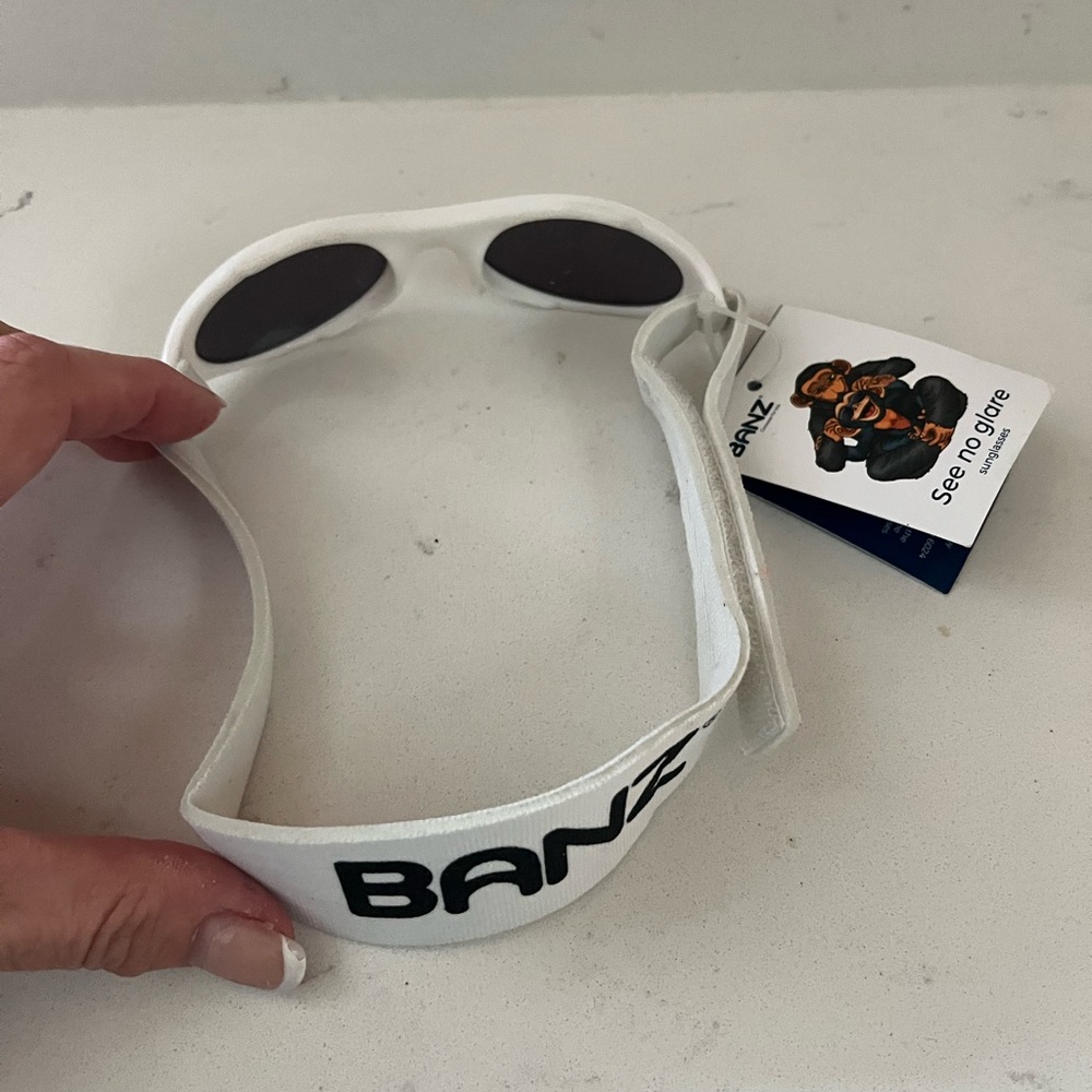 Baby Banz sunglasses new w tags, White baby Banz sunglasses & strap no glare
